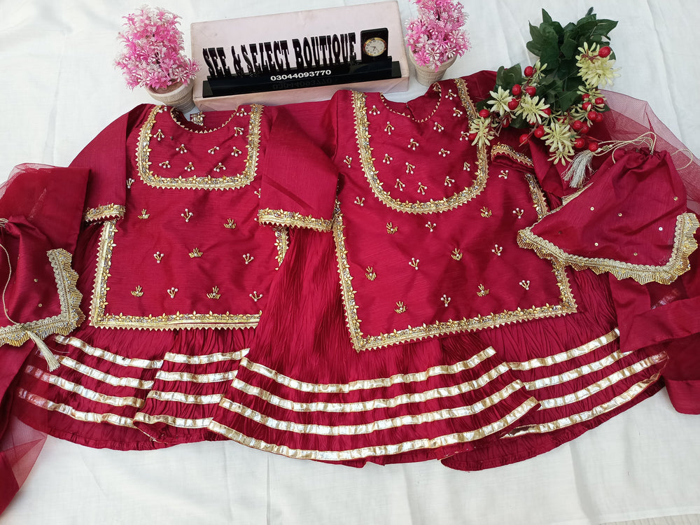 Red embroidered fabric with gold patterns on a white background